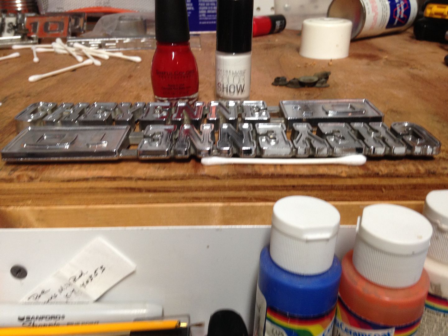 Painting emblems using lacquer paint and a hypodermic syringe The